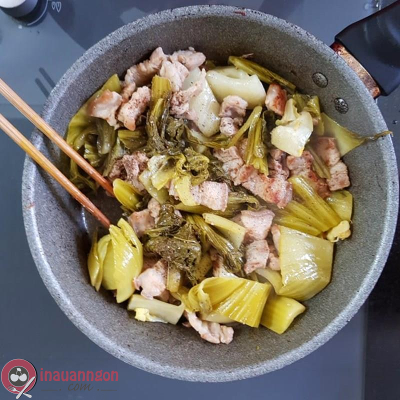 Xào rau cải chua với thịt heo trên bếp